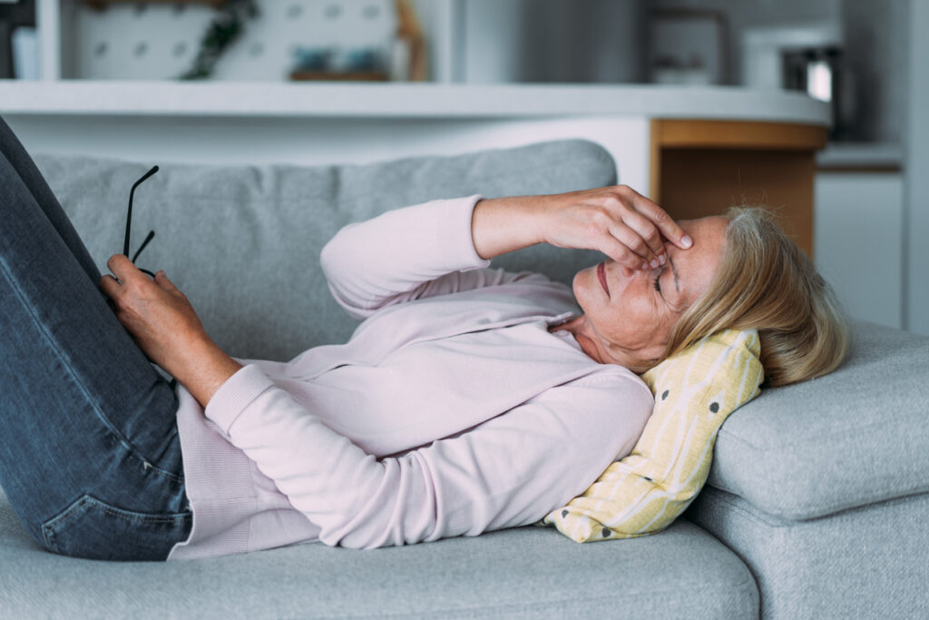 Shot of a mature woman suffering from a headache at home.